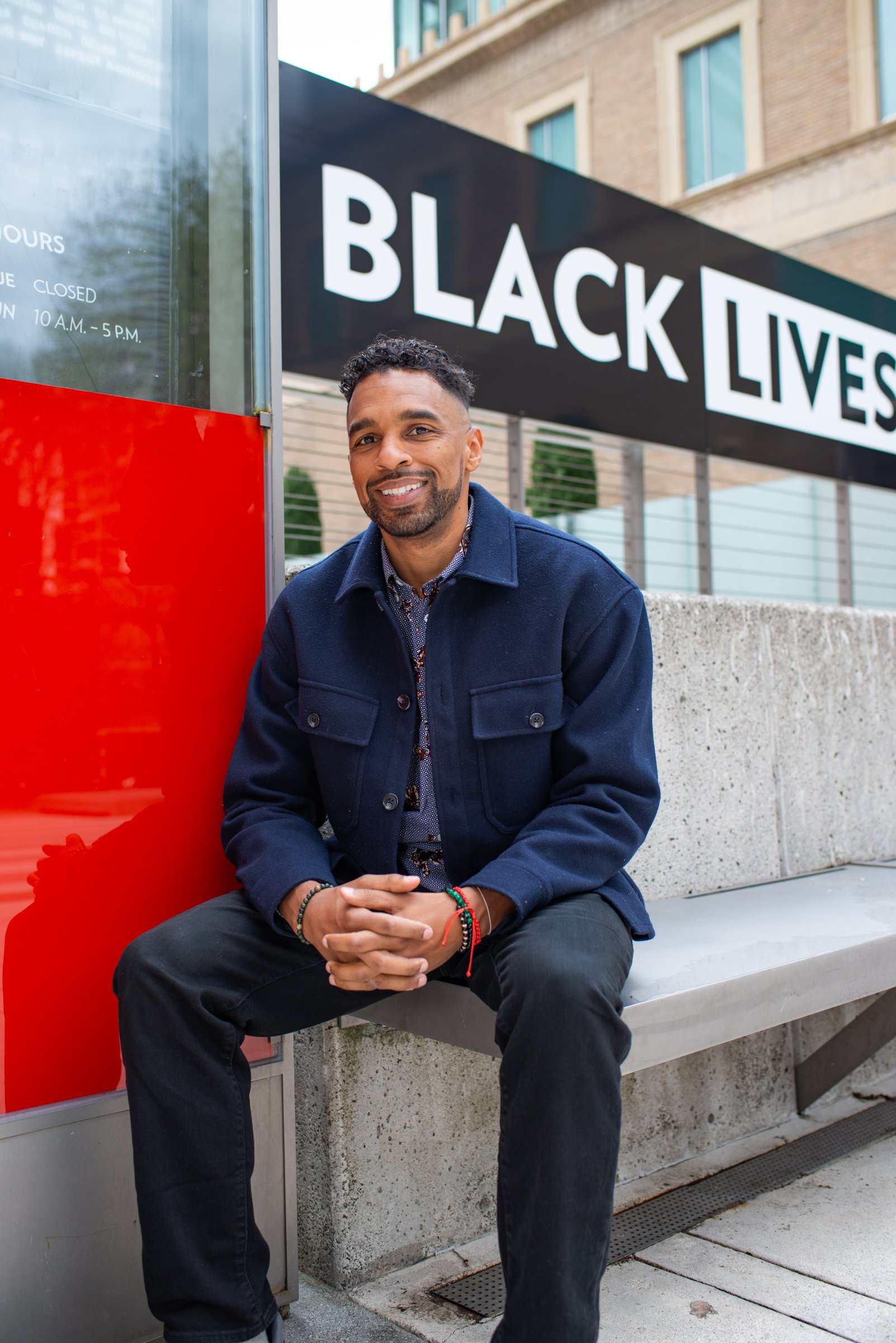 Jordan Thierry sits in front of a Black Lives Matter sign
