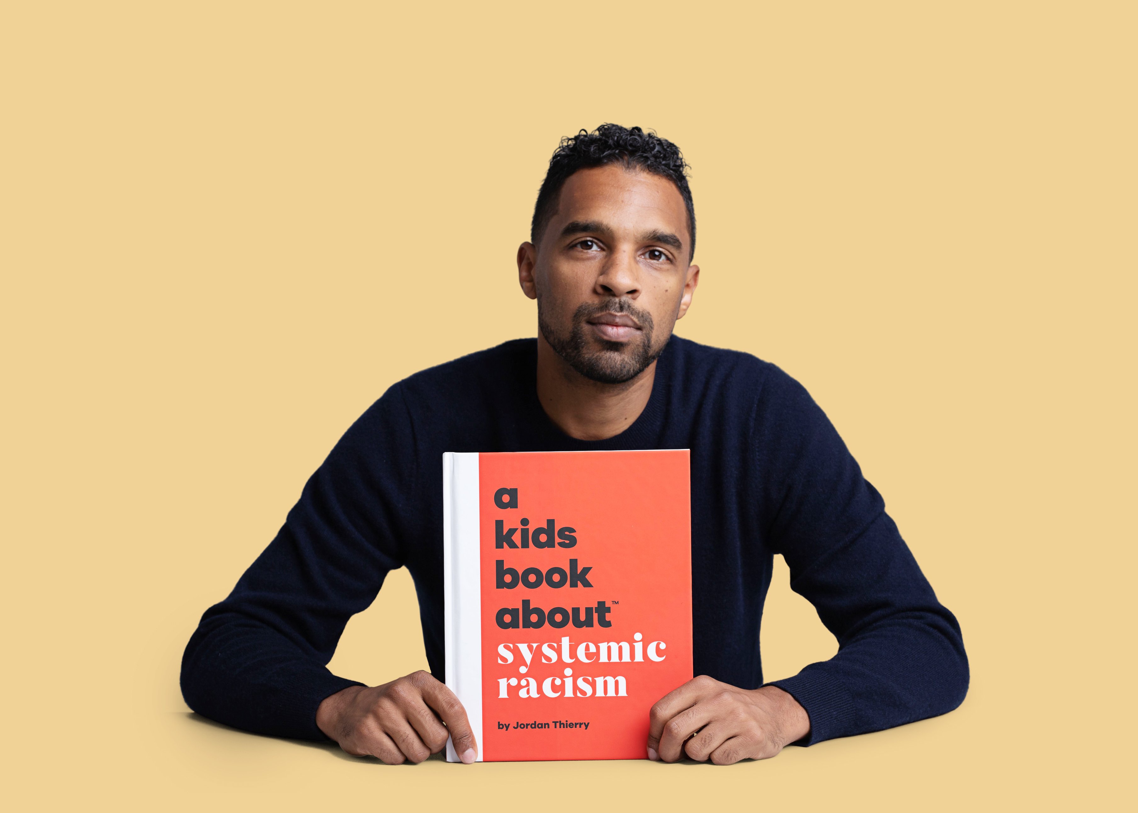 Jordan Thierry holds his book, A Kids Book about System Racism