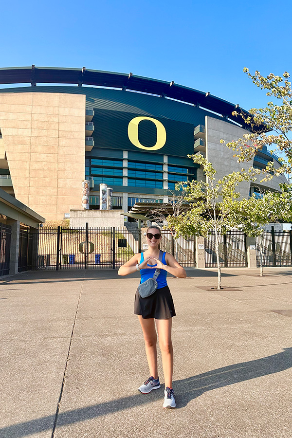 Maddy Carson throwing an O in front of Autzen
