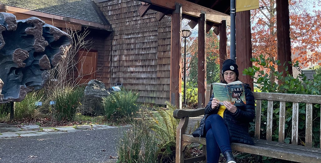 Woman reading on a bench on UO's Eugene campus