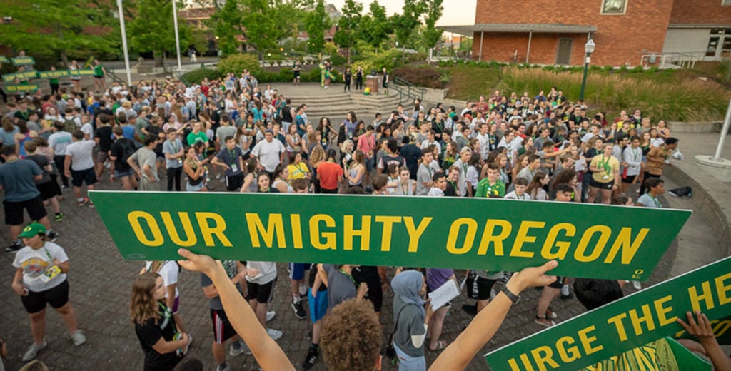 Our Mighty Oregon sign being held up by a fan