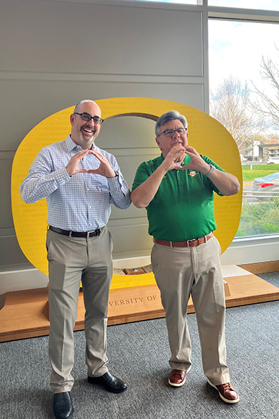 Current UO Alumni Association Executive Director Raphe Beck (left) and former UOAA Executive Director Dan Rodriguez (right) throw their Os.