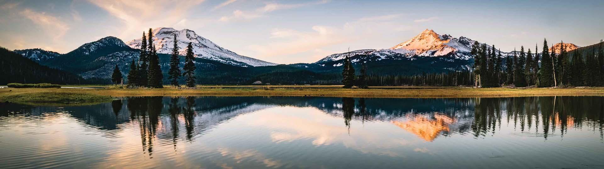 Lake in Central Oregon with mountains and trees in background