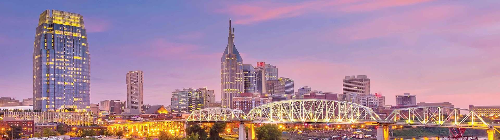 City skyline of Nashville lit up at night over the river