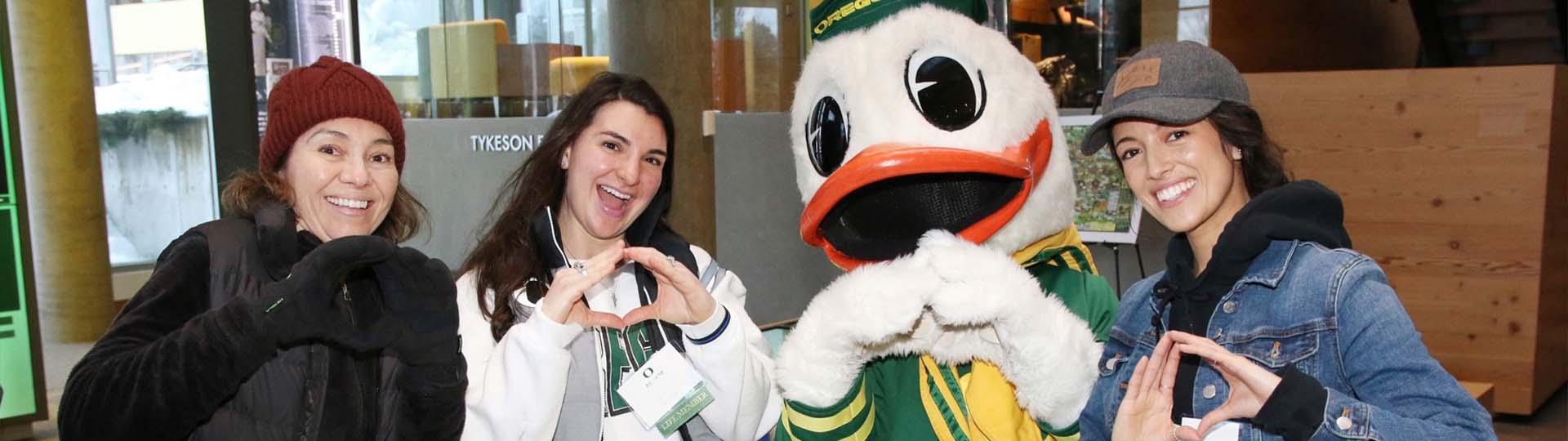 three alumni at membership appreciation event with the Duck 