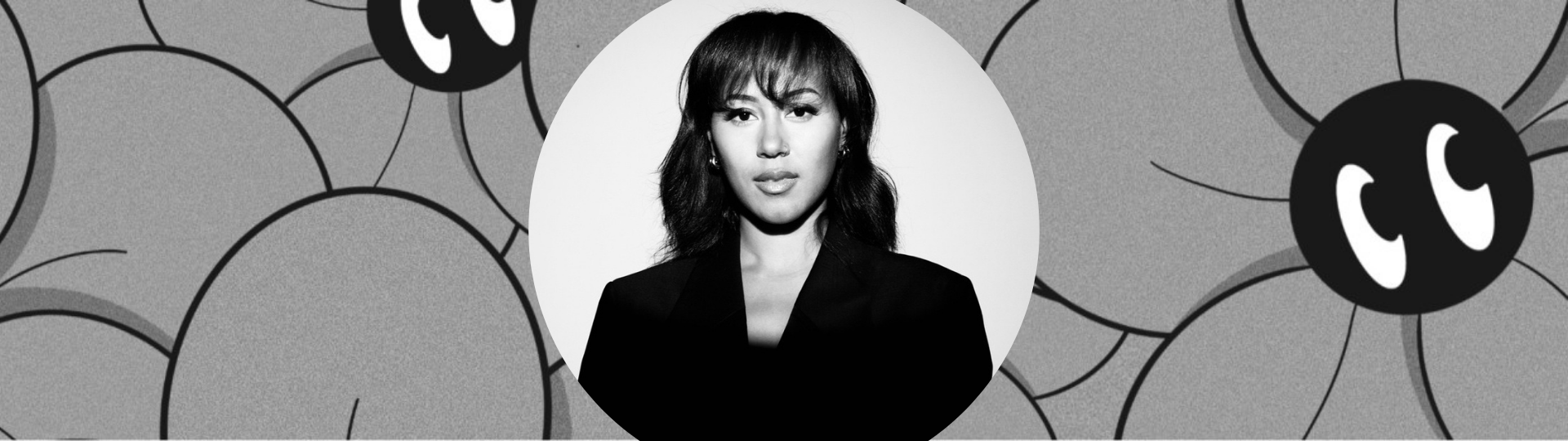 A black and white photo of Nia Pennington centered on gray cartoon flowers with cartoon eyes that she drew.