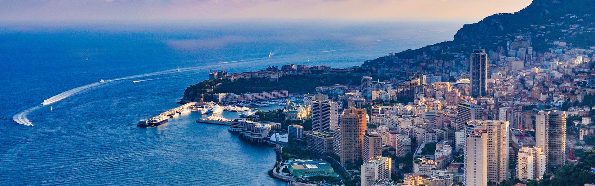Blue water meets a hill covered in city buildings.