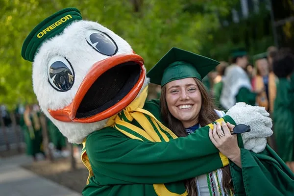 The Duck hugs a UO grad during Commencement