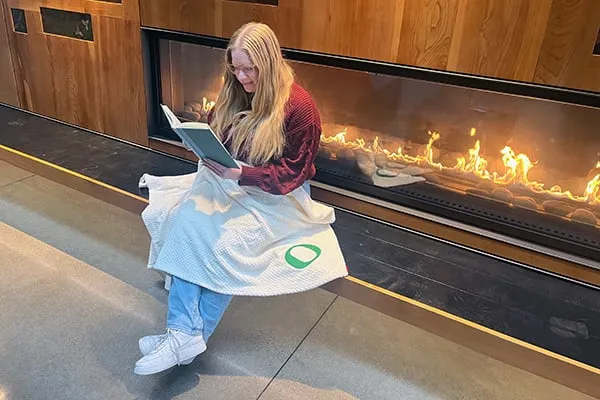 Woman reading on a bench in UO's Eugene Ford Alumni Center