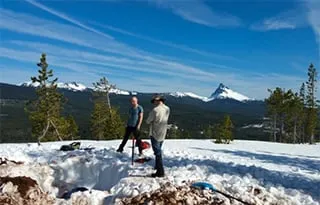UO graduate students servicing ShakeAlert site DFAZ in the high Cascades; Mt. Thielsen in background