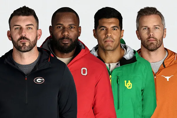 Four male men side by side wear different university jackets. 