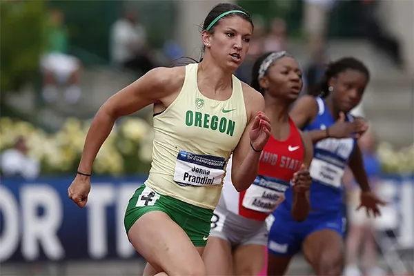 A female University of Oregon track runner running during a race. 