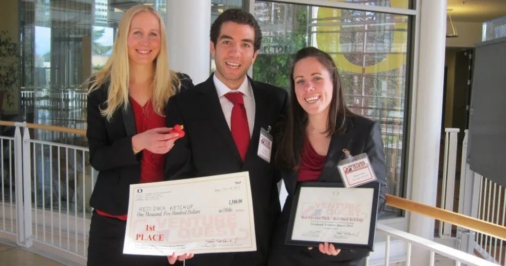 Two females and a male holding certificates wearing formal attire. 