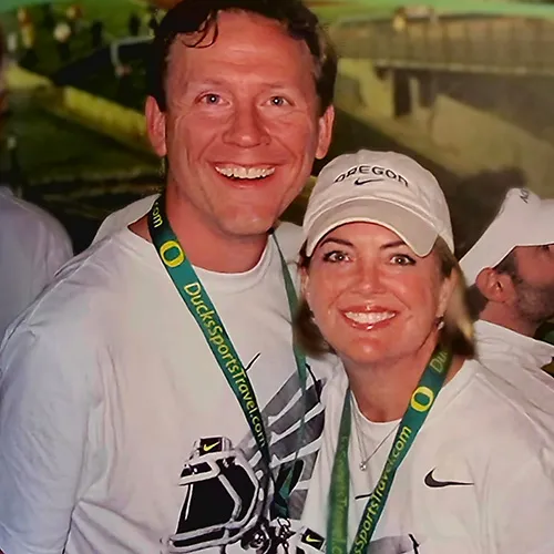 A male and female side-by-side wearing white tee shirts and Oregon lanyards. 