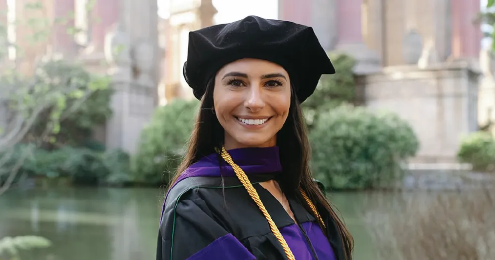 A headshot of a law student wearing a traditional law academic gown. 