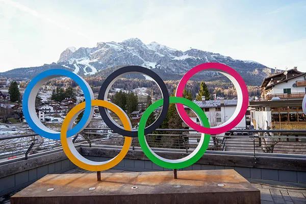 The Olympic Rings on a platform in front of the mountains in Milan, Italy for the 2026 Winter Olympic Games.