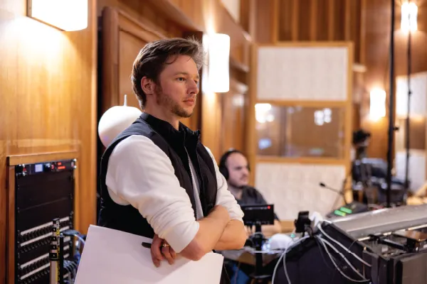 A music conductor standing with their arms crossed. 