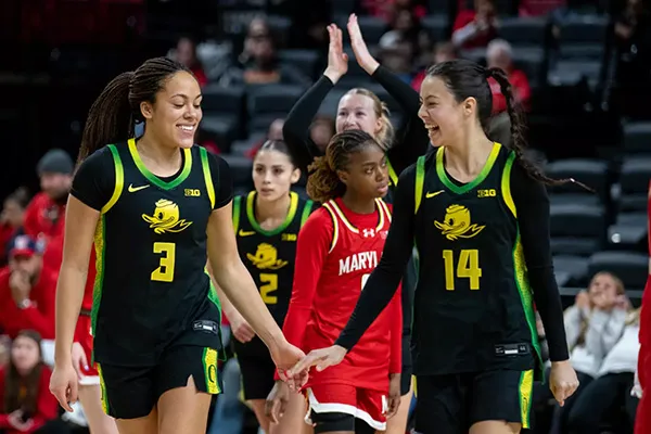 Two female basketball players during a game. 