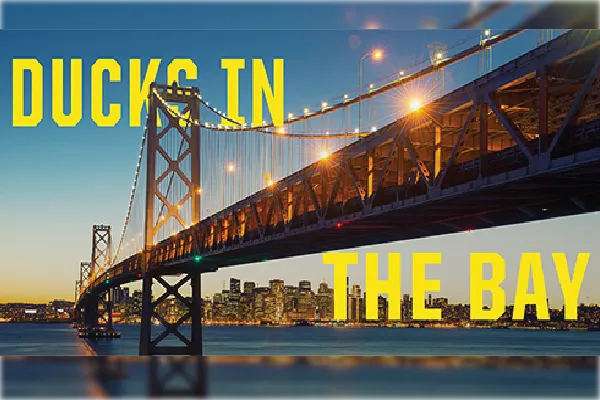 Ducks in the Bay yellow text on a photo of the Golden Gate Bridge at sunset.