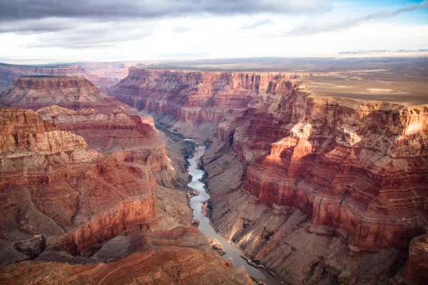 TA river runs through the red striped walls of the Grand Canyon.