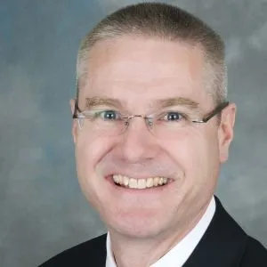 A headshot of Edward Weaver, a white man in glasses.