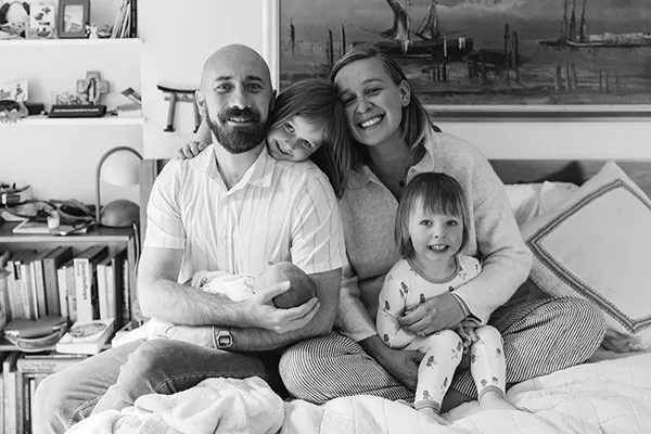 A black and white Flannery family photo of a man, and woman, two little girls, and a baby.