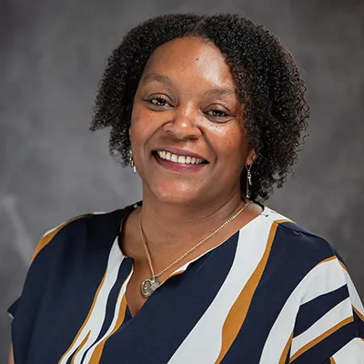 Timisha Wilson, a Black woman in a striped blouse.