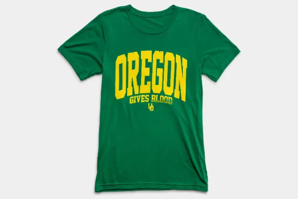 A green t-shirt with yellow varsity font text that says Oregon Gives Blood.