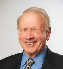 A headshot of Dr. Larry Large, a white man in a suit.