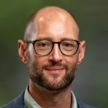 A headshot of Elliot Berkman, a white man in glasses.