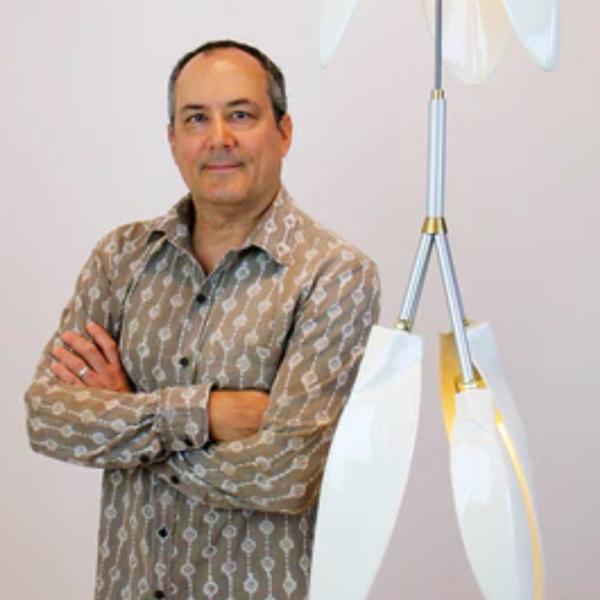 Shea Bajaj posing in front of a light fixture