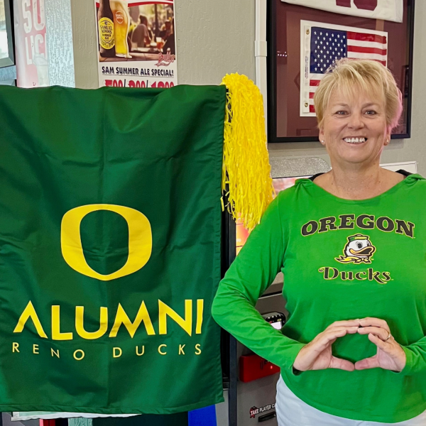 Lynn Heislein throws her O next to a Reno Ducks flag