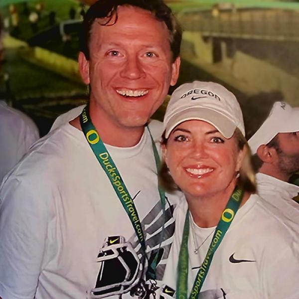 A male and female side-by-side wearing white tee shirts and Oregon lanyards. 