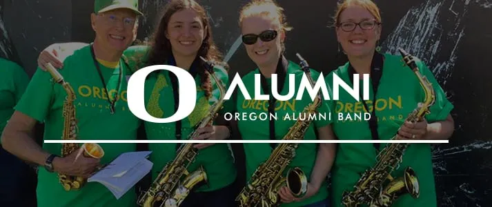 Members of Oregon Alumni Band with logo in front