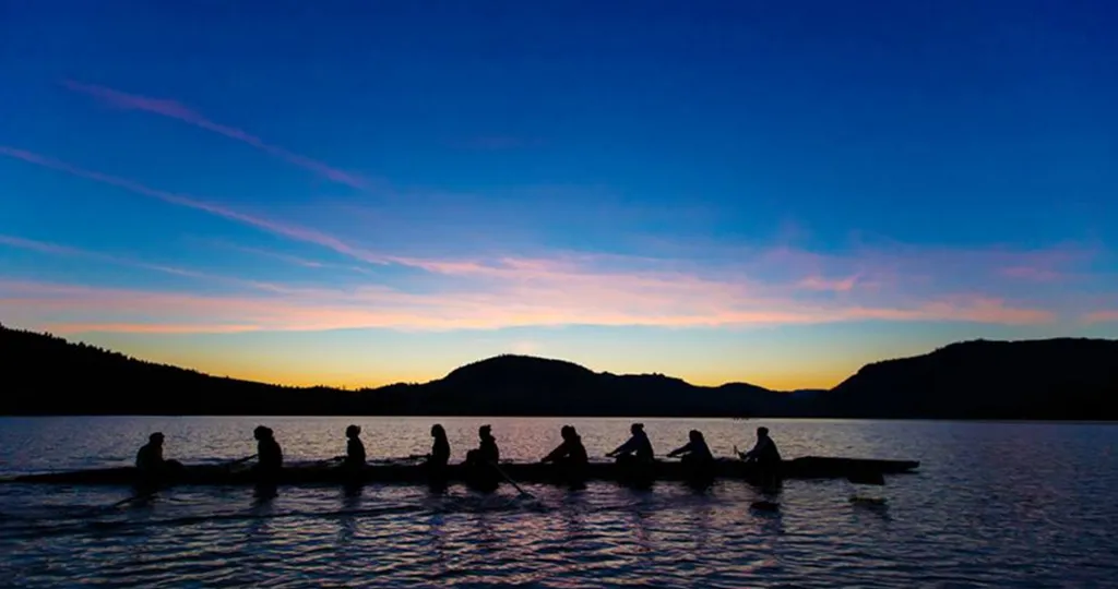 rowers on lake at sunrise