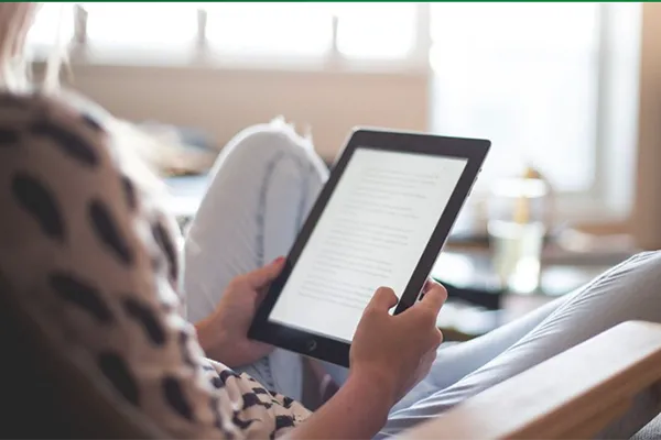 woman reading book on a tablet