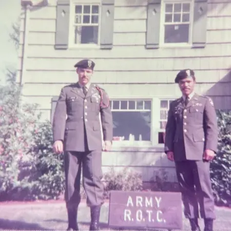 Two people in uniform standing in front of UO ROTC army building