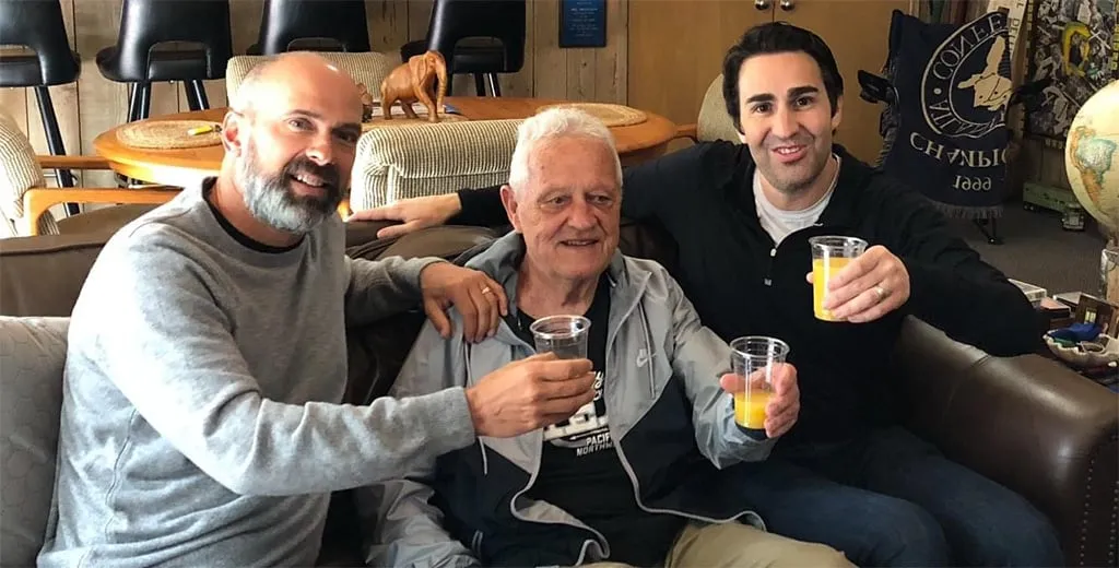 Bill Dellinger toasts with former athletes John Truax and Philip Levinson