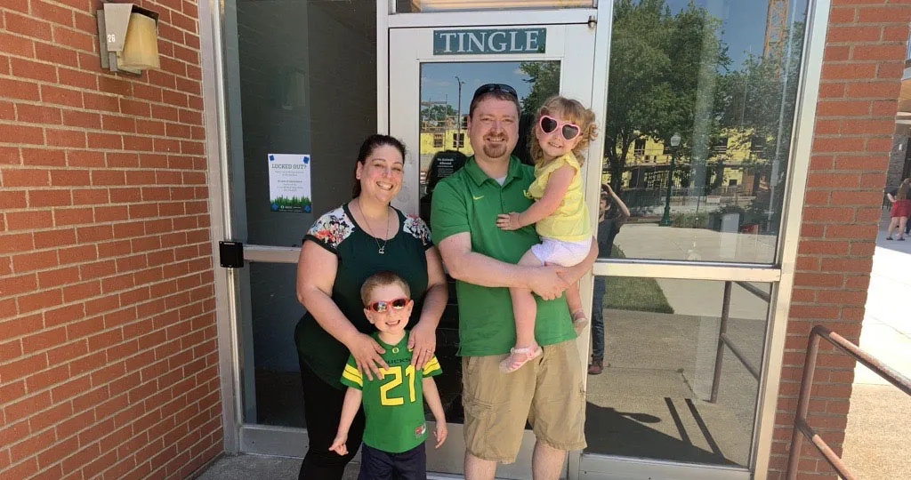 Two parents a two kids pose for a picture wearing University of Oregon gear. 