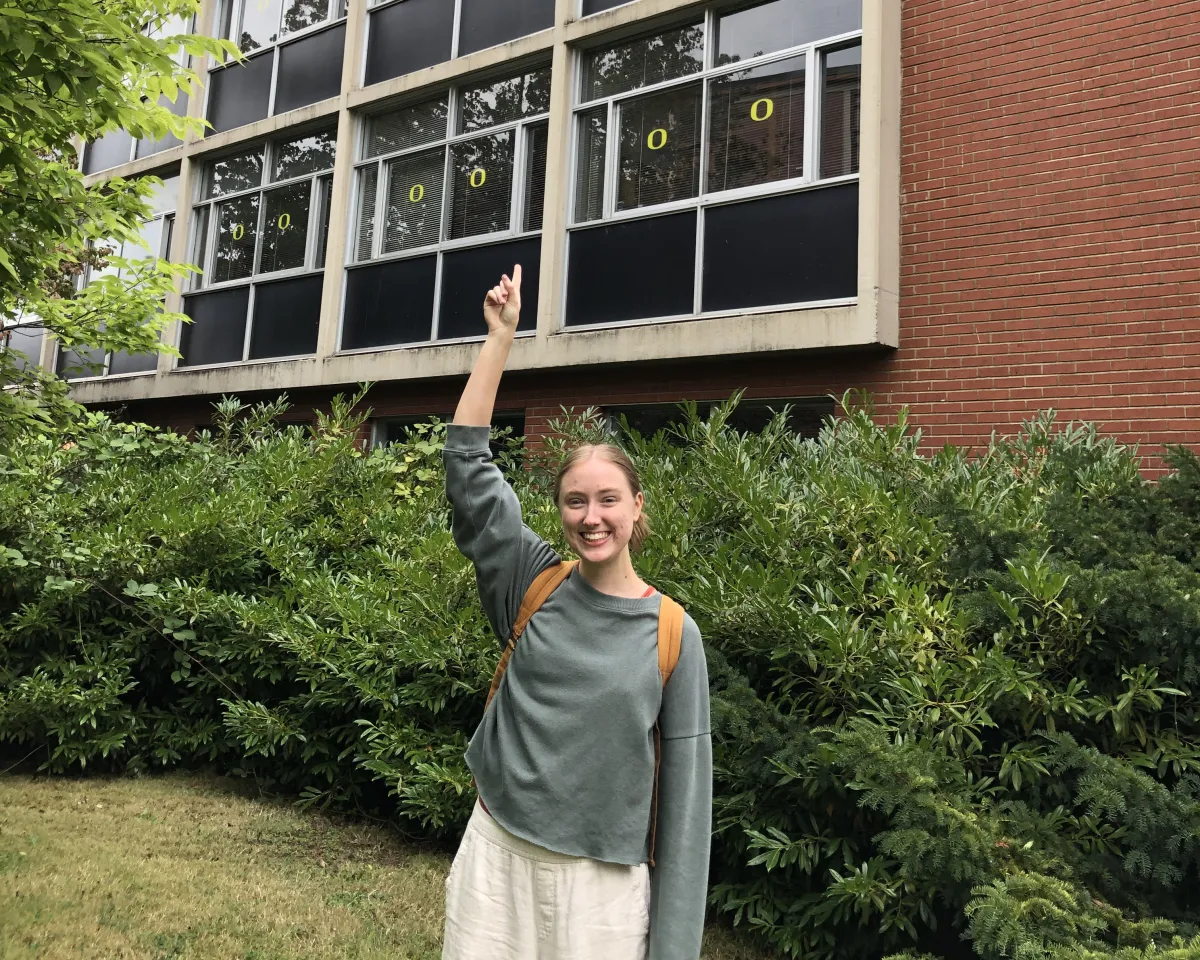 A female student pointing at Hamilton Hall where she once stayed. 
