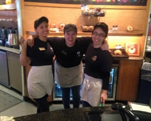 Three friends pose for a picture while working their work shift. 