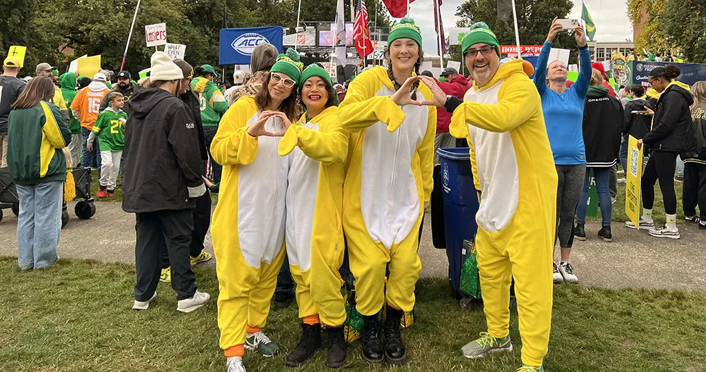UO Alumni Association staff pose in Duck onesies at College GameDay