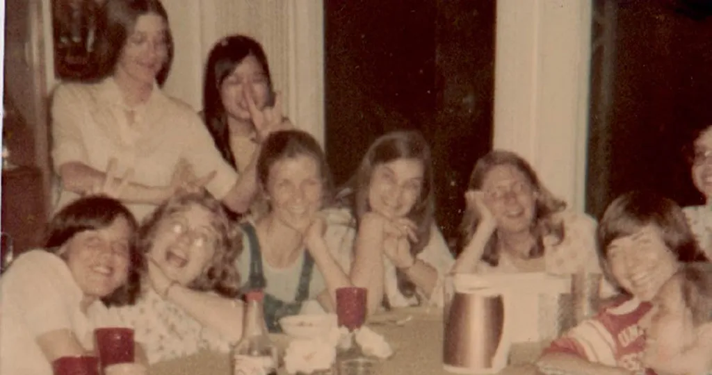 Jenny Bender, Sharon Bryan, Karen Coon, Susan Scovil, Mary Jo Kealy, Cat Weber, Faye Blumenthal, Patty Pavel Lentz, Lexie Caswell, and Susan Ota, sit around a table with red cups and white mugs in front of them.