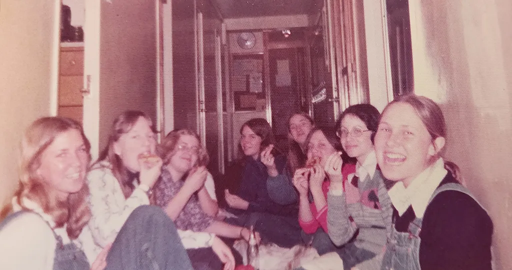 The "D-Wing Ladies" and their friends share pizza in the hallway of Carson Hall.