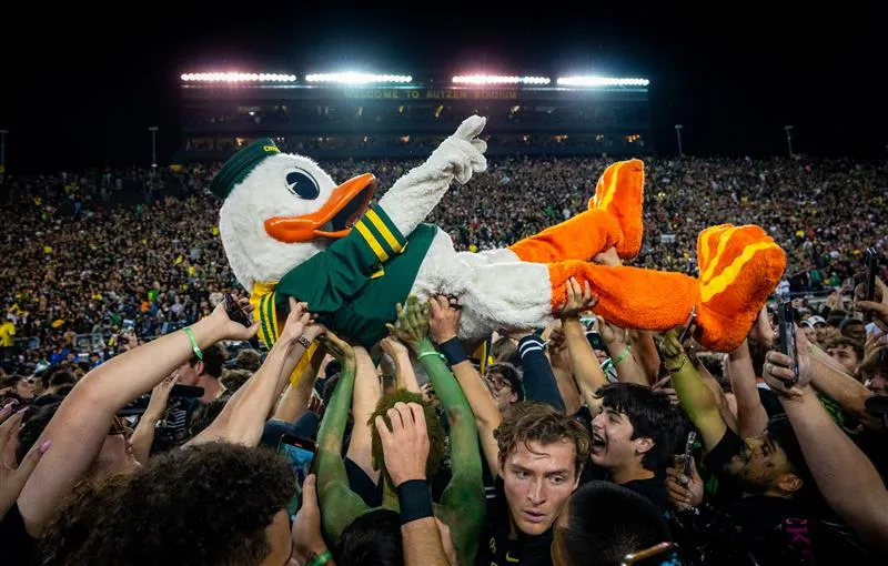 The Oregon Duck crowd surfs on the field of Autzen Stadium