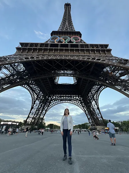 Katrina Galas stands below the Eiffel Tower in Paris, France, which is adorned with the Olympic Rings.