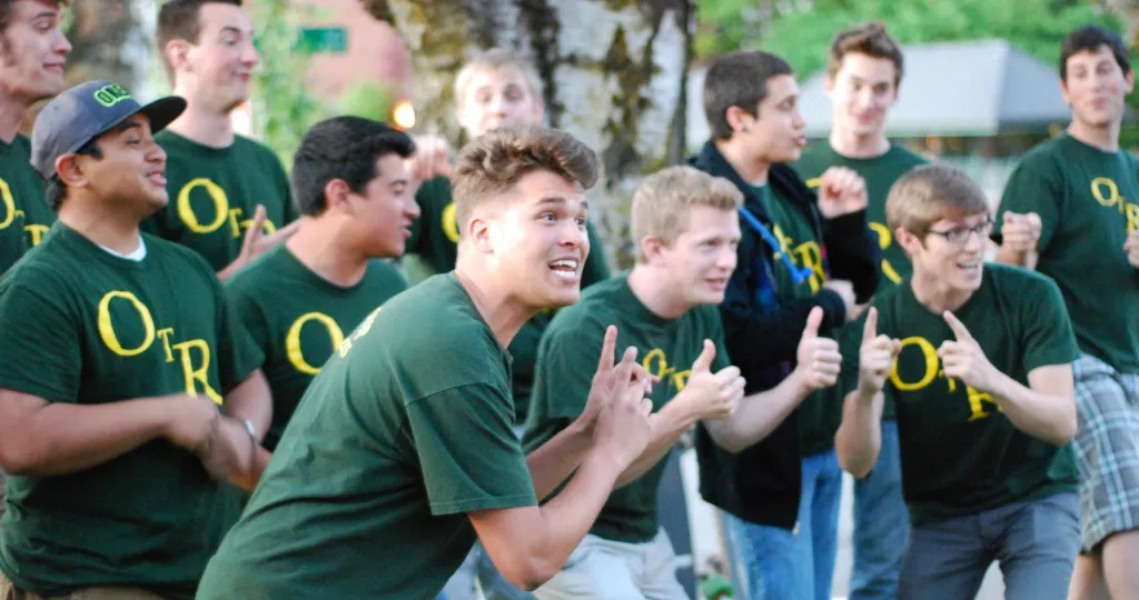 Jeff Rogers and On the Rocks perform on the University of Oregon campus in dark green shirts that have the letters OTR in yellow on the fronts.