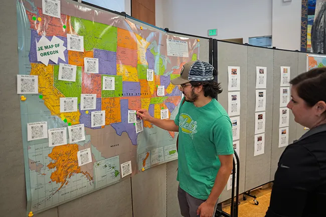 A graduating student pins their next destination on a map of the US