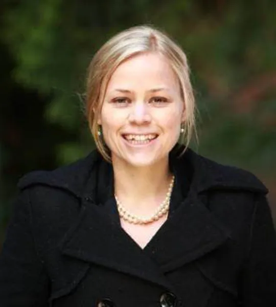 A headshot of Guru Larson, a white woman in a black coat.