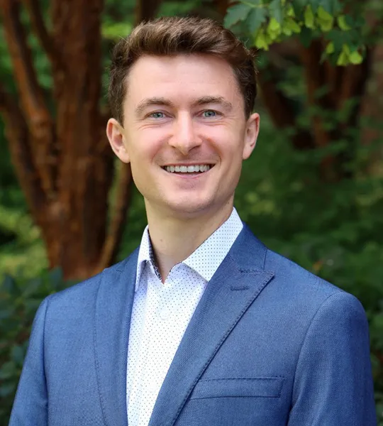 A headshot of James Schulte, a white man in a light blue suit.